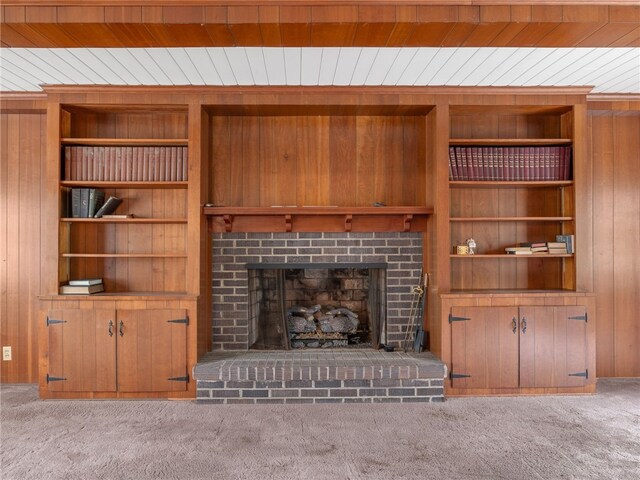 unfurnished living room with a fireplace, wooden walls, and wood ceiling