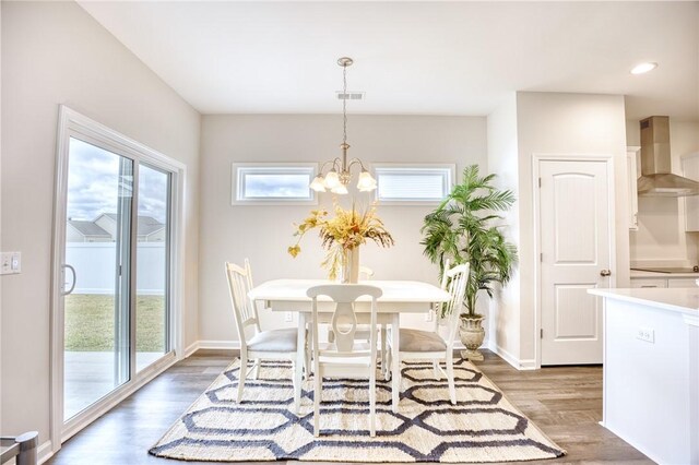 dining space with wood-type flooring and a notable chandelier