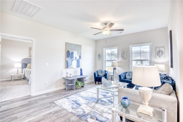 living room featuring ceiling fan and light hardwood / wood-style flooring