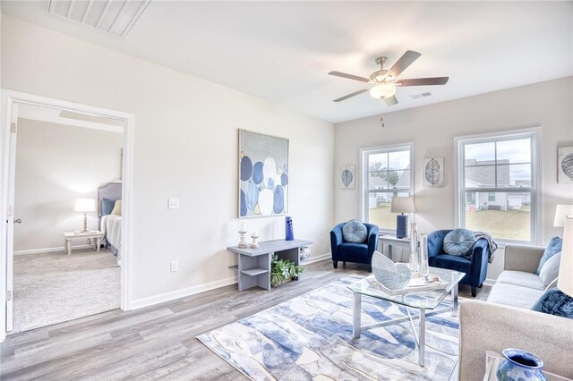 living room featuring light hardwood / wood-style flooring and ceiling fan