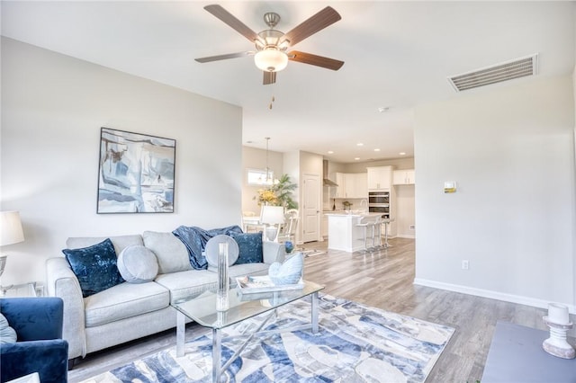 living room featuring ceiling fan and light wood-type flooring