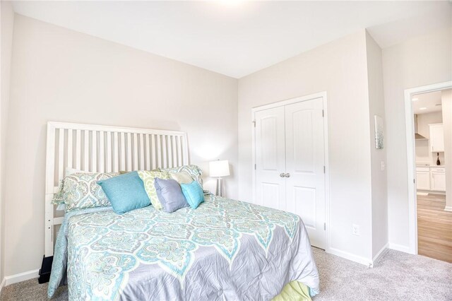 bedroom with light carpet and a closet