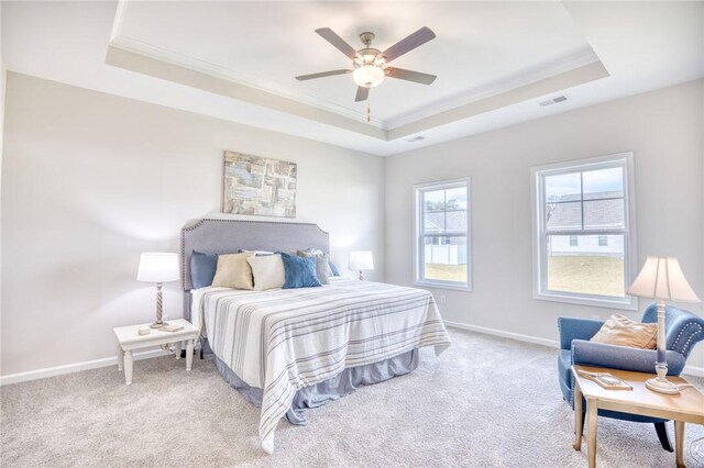 carpeted bedroom featuring ornamental molding, a raised ceiling, and ceiling fan