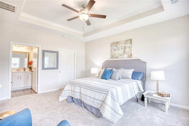 bedroom with ceiling fan, ornamental molding, a raised ceiling, and light colored carpet