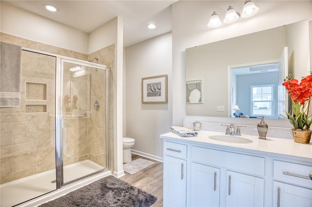 bathroom with an enclosed shower, vanity, hardwood / wood-style flooring, and toilet