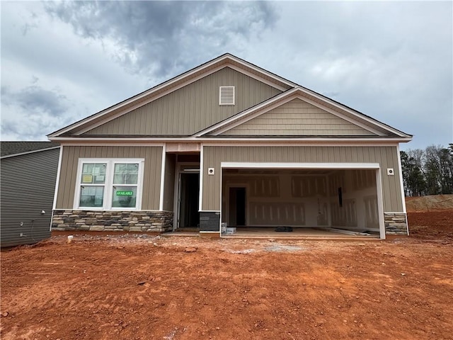 craftsman-style house with a garage and stone siding