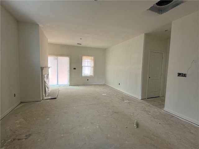 empty room featuring baseboards and a fireplace with raised hearth