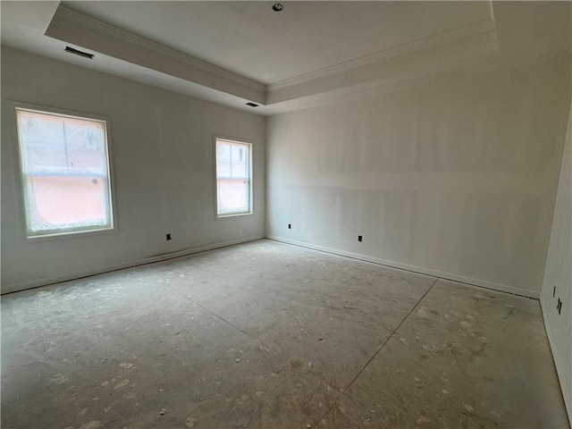 empty room with visible vents, a raised ceiling, and ornamental molding