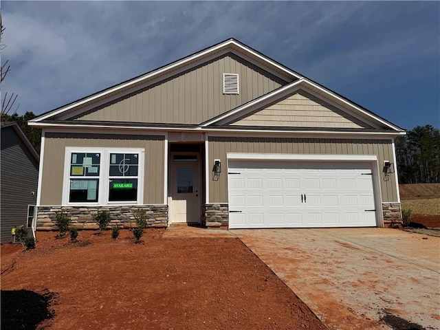 craftsman-style house with a garage, stone siding, and concrete driveway