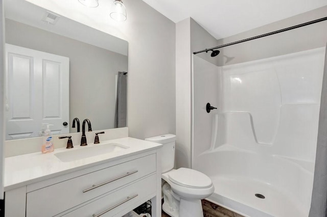 bathroom with vanity, toilet, and walk in shower