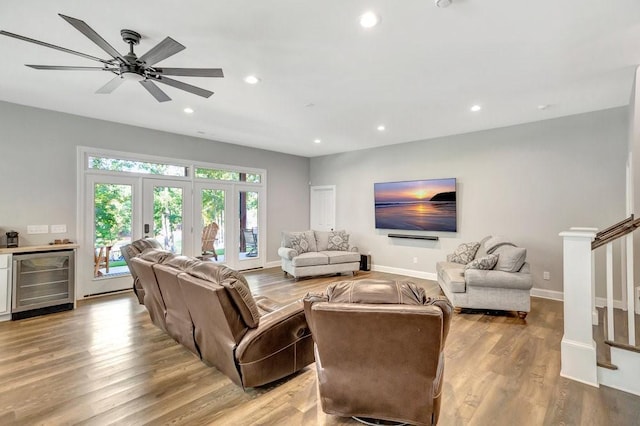 living room featuring ceiling fan, french doors, beverage cooler, and light hardwood / wood-style floors