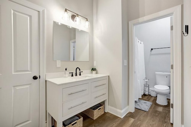 bathroom with vanity, wood-type flooring, and toilet