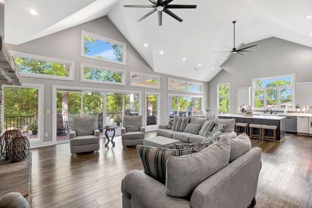 living room featuring dark hardwood / wood-style floors, ceiling fan, sink, and high vaulted ceiling