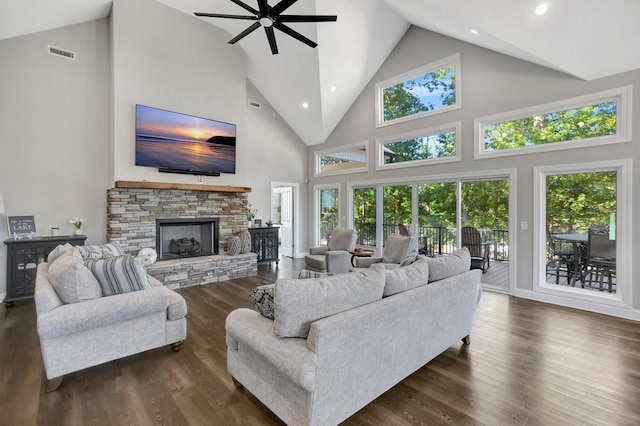 living room featuring ceiling fan, dark hardwood / wood-style floors, a fireplace, and high vaulted ceiling