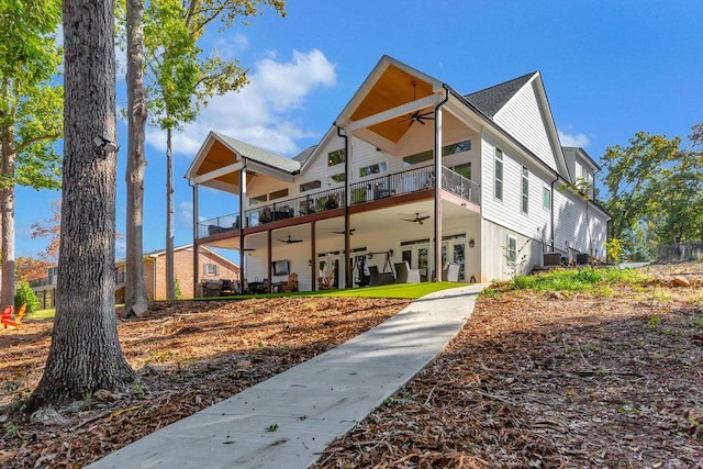 back of property featuring ceiling fan and a balcony