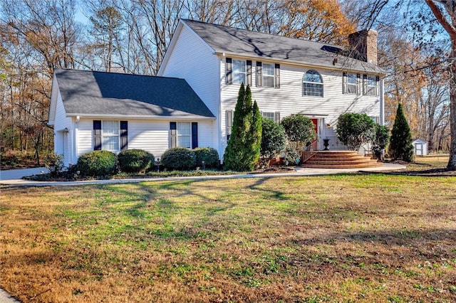 colonial inspired home with a front lawn