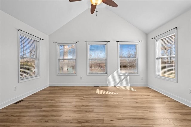 empty room featuring light hardwood / wood-style floors, vaulted ceiling, and ceiling fan