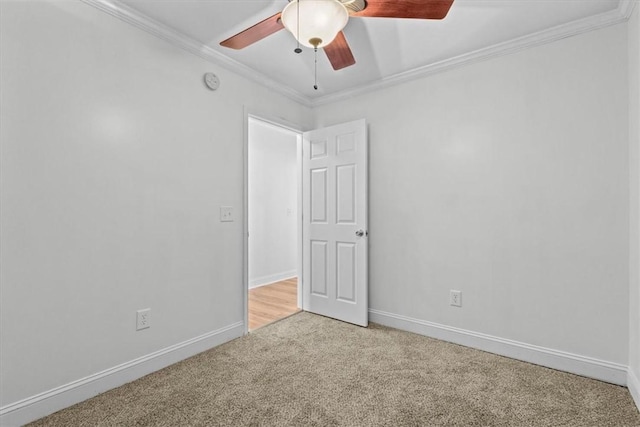 carpeted spare room with crown molding and ceiling fan