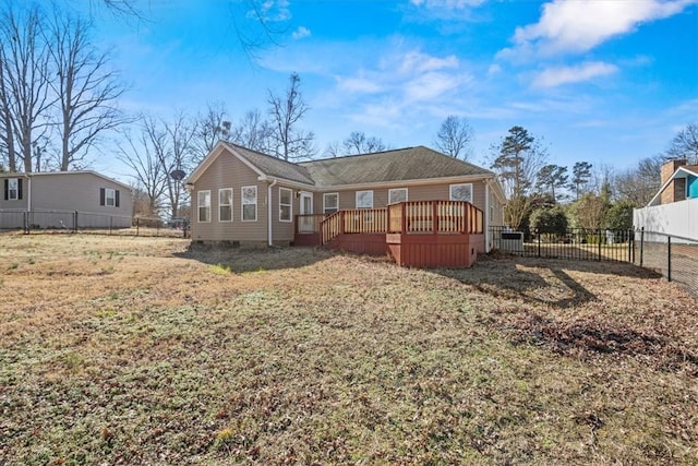 rear view of house featuring a lawn and a wooden deck