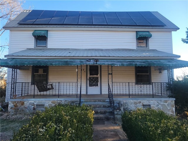 view of front of house featuring covered porch and solar panels