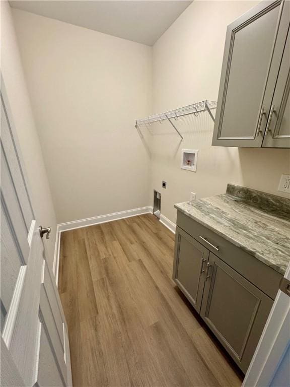 laundry area featuring cabinets, washer hookup, light wood-type flooring, and electric dryer hookup