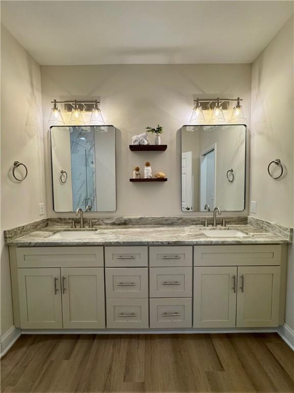 bathroom with hardwood / wood-style flooring, vanity, and a shower with door