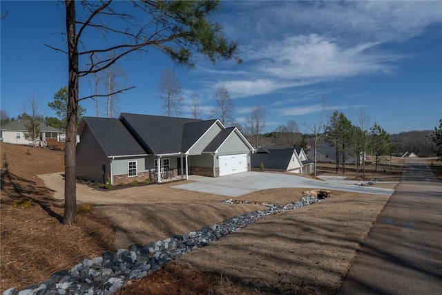 view of front of home featuring a garage, stone siding, driveway, and a porch