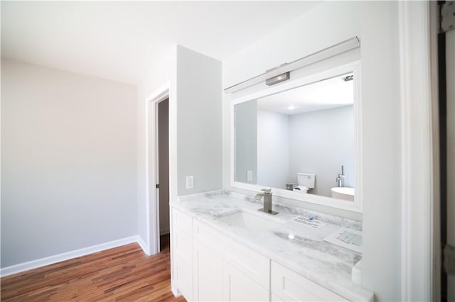 bathroom featuring wood-type flooring, vanity, and toilet