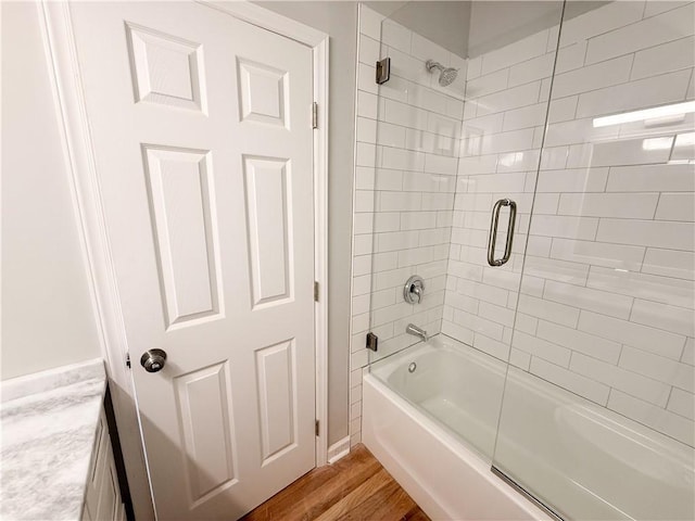 bathroom featuring enclosed tub / shower combo and wood-type flooring