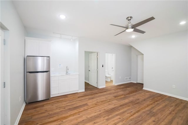 interior space with hardwood / wood-style flooring, ceiling fan, and sink