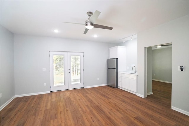 spare room featuring dark wood-type flooring, track lighting, french doors, sink, and ceiling fan