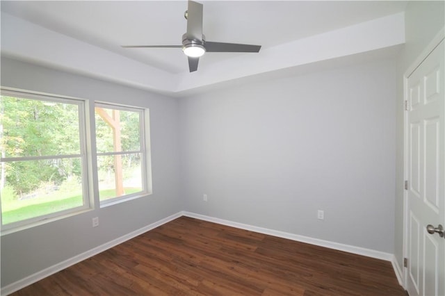 empty room with ceiling fan and dark hardwood / wood-style flooring