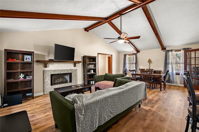 living room with hardwood / wood-style floors, lofted ceiling with beams, and plenty of natural light