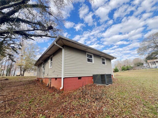 view of property exterior featuring a lawn and central air condition unit