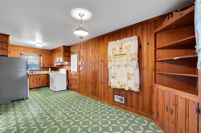 kitchen featuring stainless steel fridge, light colored carpet, sink, decorative light fixtures, and white electric range