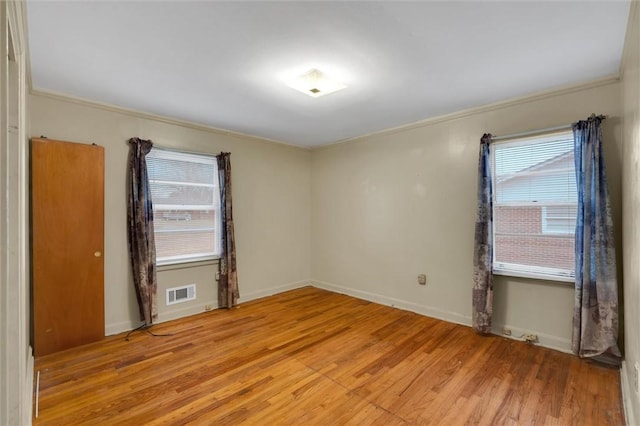 unfurnished room featuring light hardwood / wood-style flooring, plenty of natural light, and crown molding