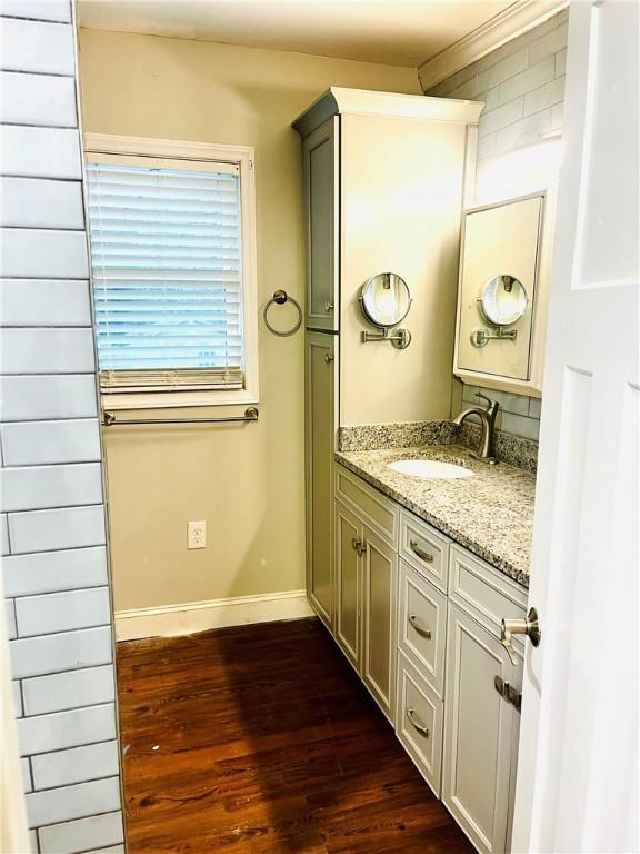 bathroom with vanity, wood-type flooring, and ornamental molding