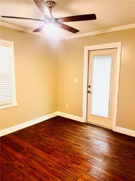 empty room featuring dark hardwood / wood-style flooring and ornamental molding