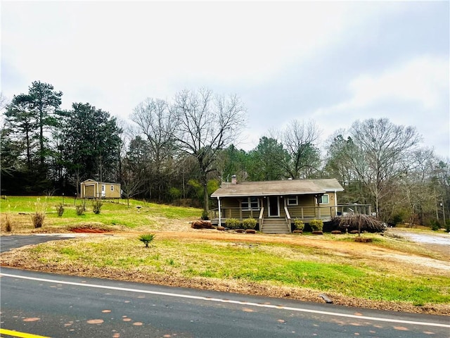 view of front of home featuring a storage unit and a porch