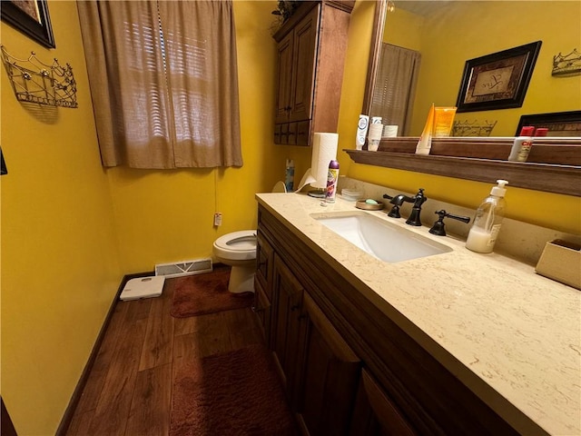 bathroom with vanity, wood-type flooring, and toilet