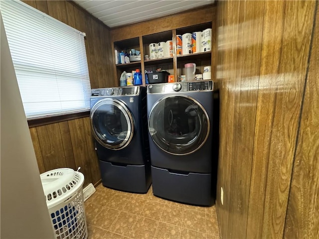 laundry room featuring wood walls and washer and dryer