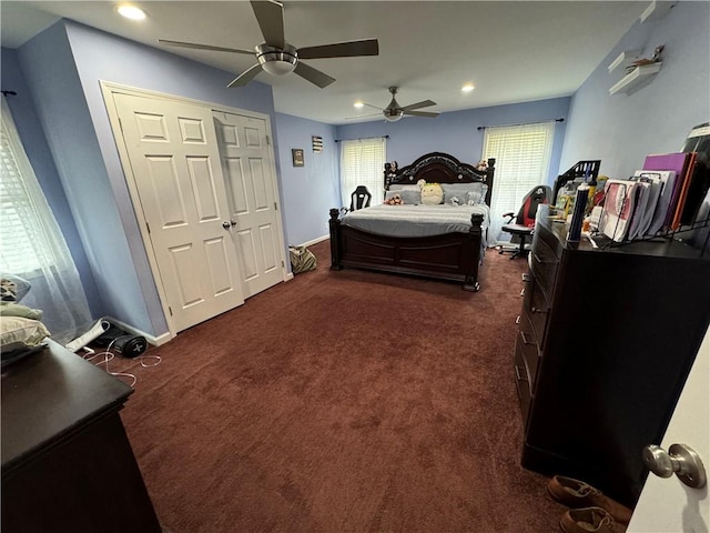 bedroom featuring ceiling fan, dark carpet, and a closet