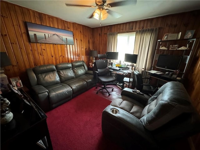 carpeted home office featuring ceiling fan and wooden walls