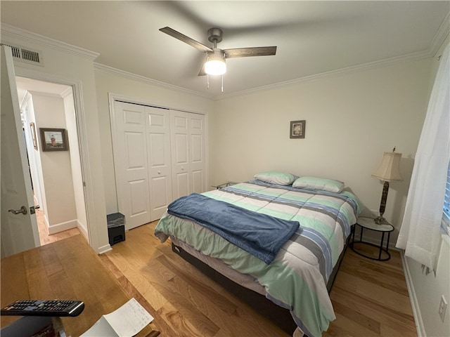 bedroom with a closet, light hardwood / wood-style flooring, ceiling fan, and ornamental molding