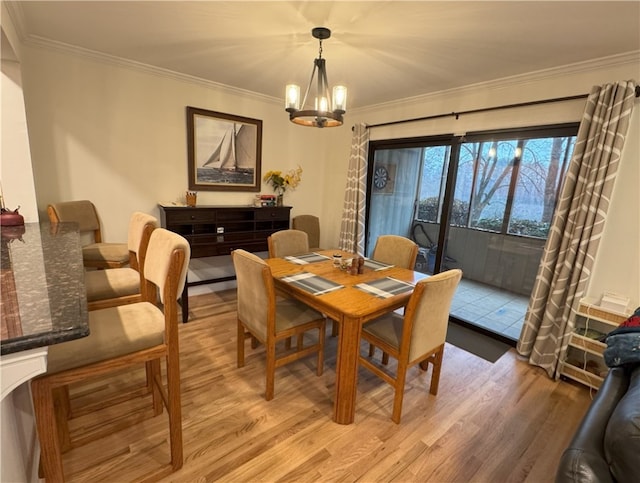 dining room featuring ornamental molding, light hardwood / wood-style floors, and an inviting chandelier