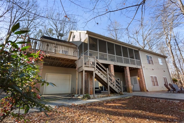 back of property with a sunroom and a garage