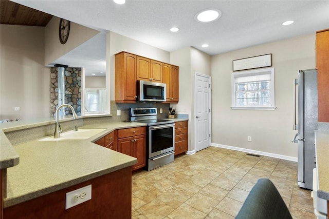 kitchen featuring kitchen peninsula, sink, plenty of natural light, and appliances with stainless steel finishes