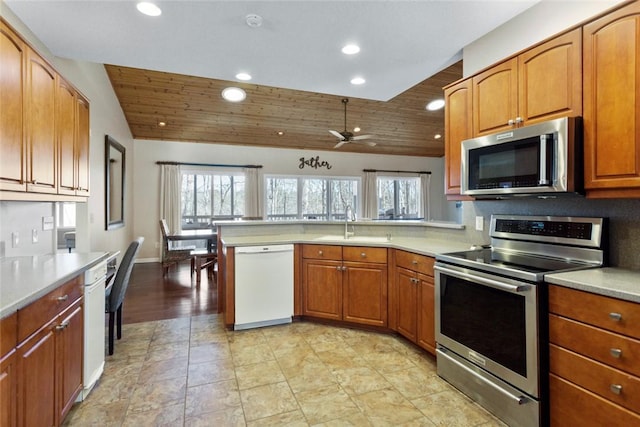 kitchen with ceiling fan, sink, kitchen peninsula, wood ceiling, and appliances with stainless steel finishes