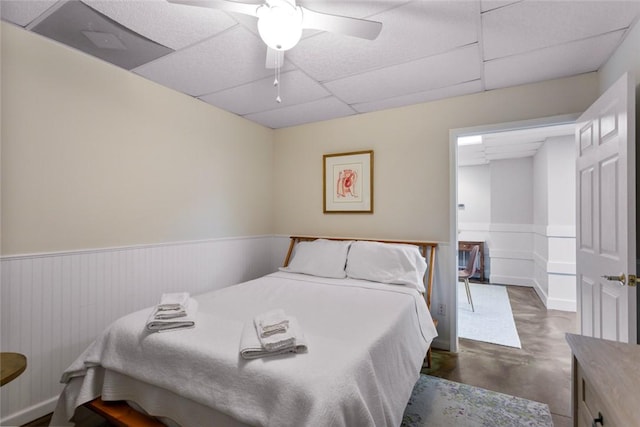 bedroom with ceiling fan and a drop ceiling