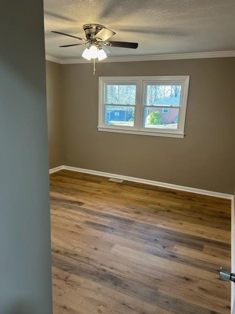 unfurnished room featuring hardwood / wood-style floors, crown molding, a textured ceiling, and ceiling fan